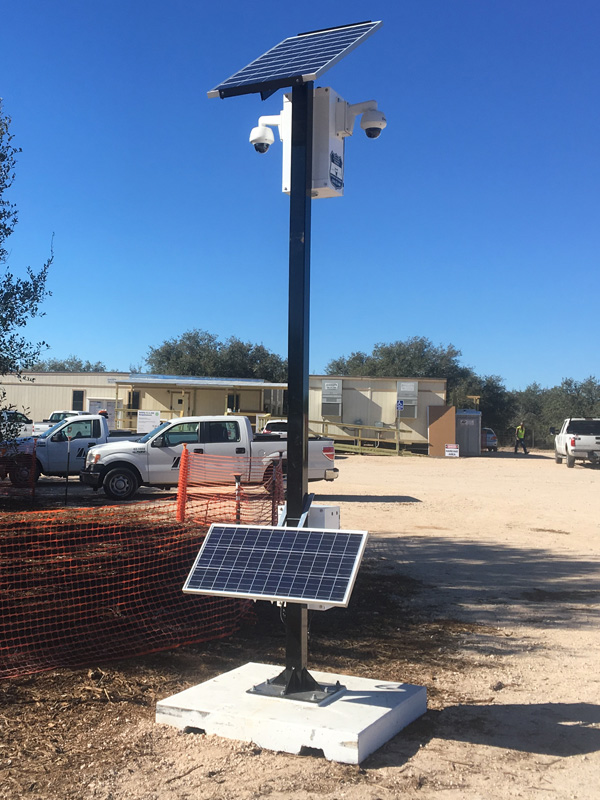 Solar-powered construction security camera tower at an active jobsite
